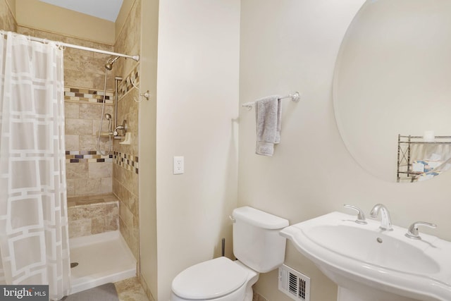 bathroom with a shower with curtain, sink, and toilet