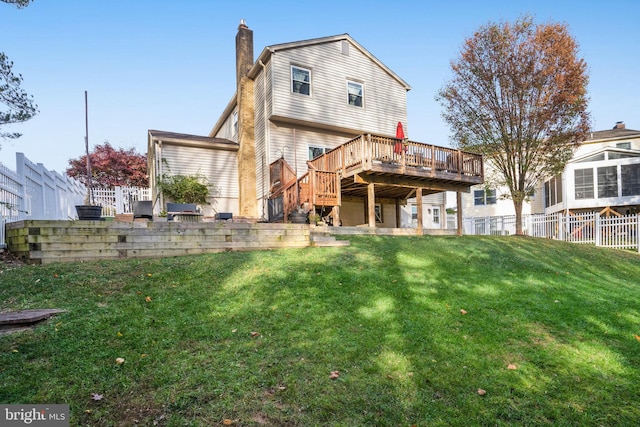 rear view of property with a yard and a wooden deck