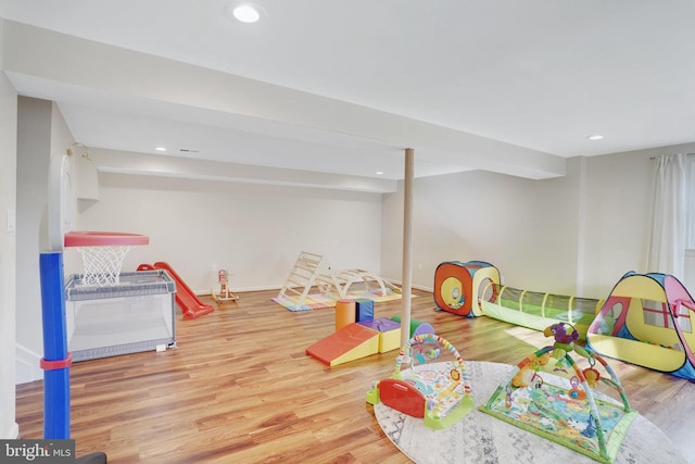 playroom featuring beamed ceiling and wood-type flooring