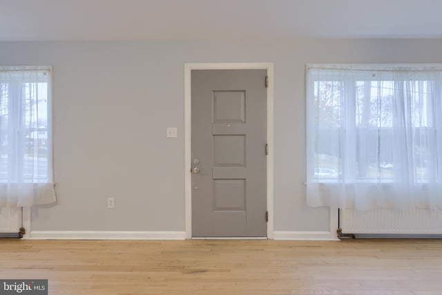 foyer entrance featuring light hardwood / wood-style floors and radiator