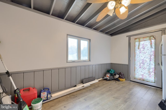 unfurnished room featuring ceiling fan, light hardwood / wood-style floors, and beam ceiling