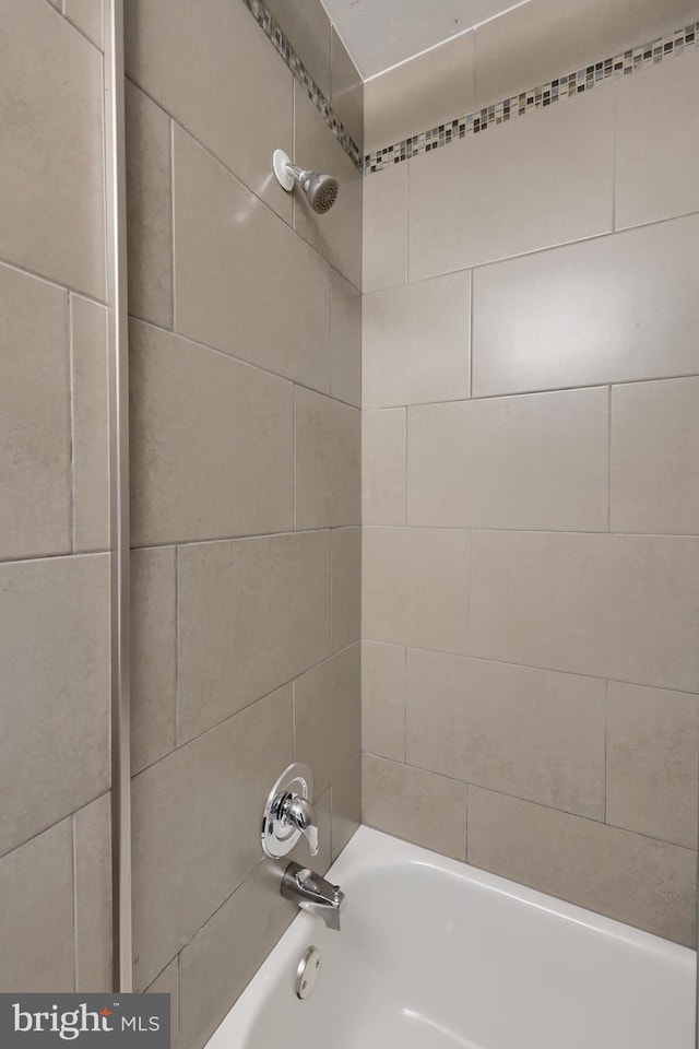 bathroom with tiled shower / bath combo