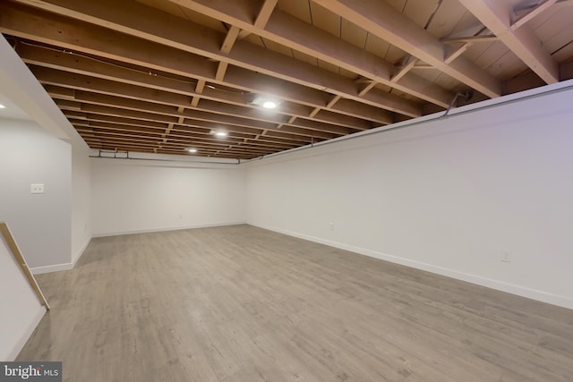 basement with hardwood / wood-style flooring