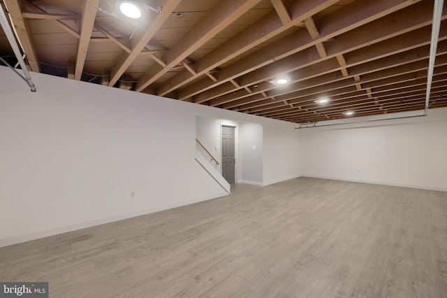 basement with hardwood / wood-style flooring