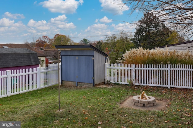 view of yard featuring a fire pit and a storage shed