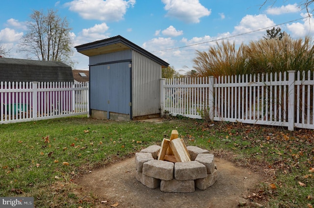 view of yard featuring a fire pit and a storage unit