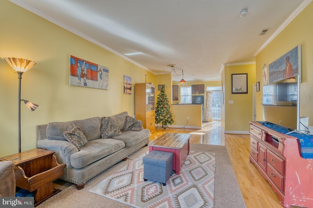 living room with ornamental molding and light wood-type flooring