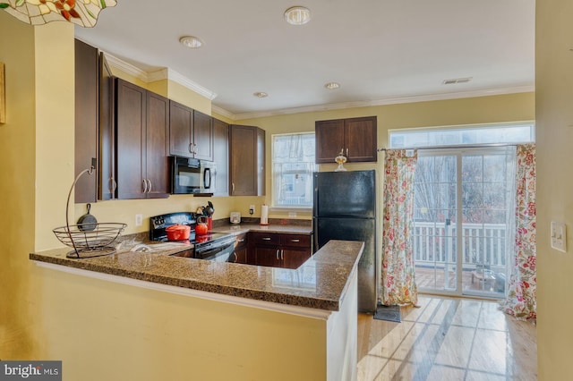 kitchen with kitchen peninsula, ornamental molding, dark stone counters, dark brown cabinetry, and black appliances