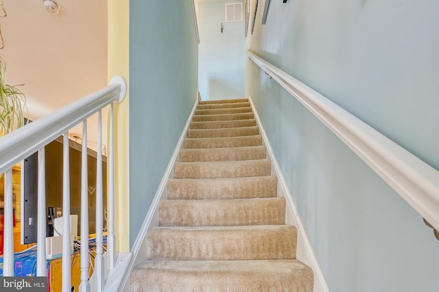 stairway featuring carpet