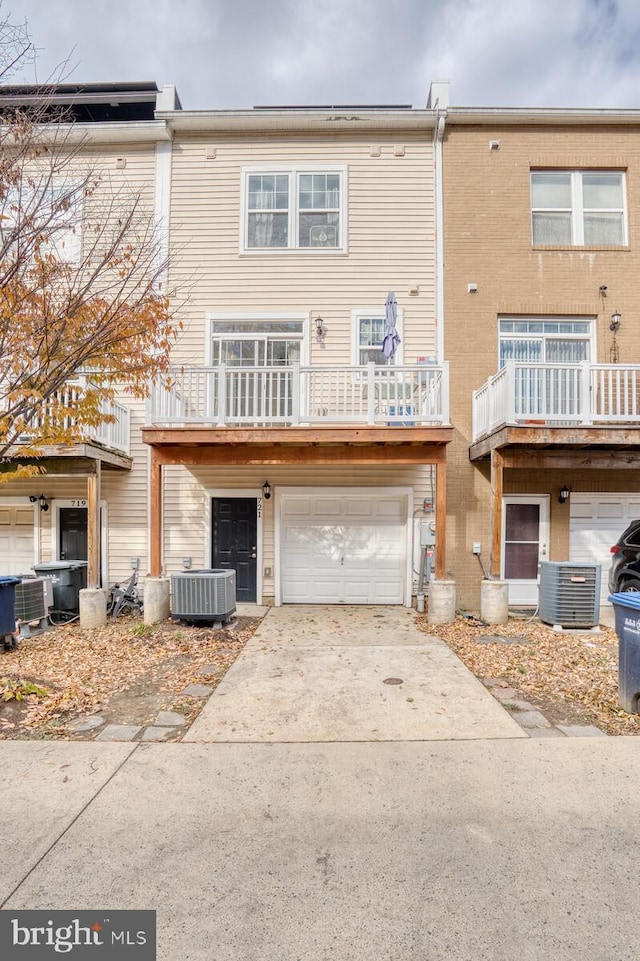 rear view of property featuring cooling unit and a garage