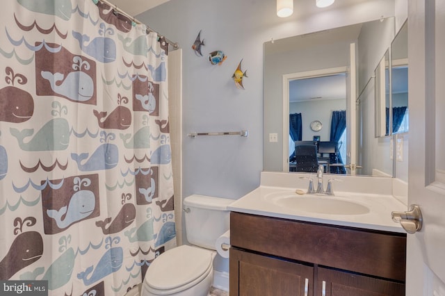 bathroom featuring a shower with shower curtain, vanity, and toilet