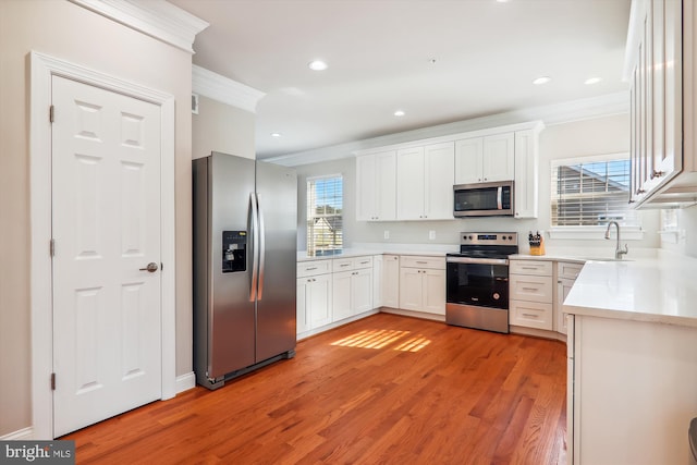 kitchen with white cabinetry, a wealth of natural light, light hardwood / wood-style flooring, and appliances with stainless steel finishes