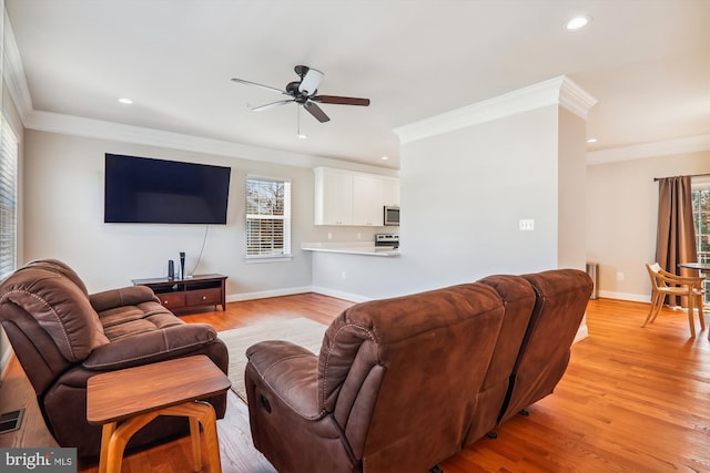 living room with light wood-type flooring, ceiling fan, and ornamental molding