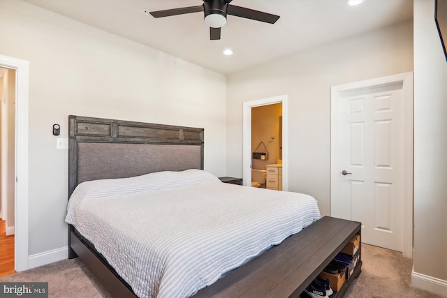 carpeted bedroom with ceiling fan and ensuite bath