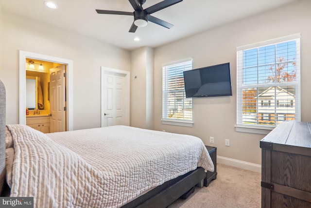 carpeted bedroom with connected bathroom, ceiling fan, and sink