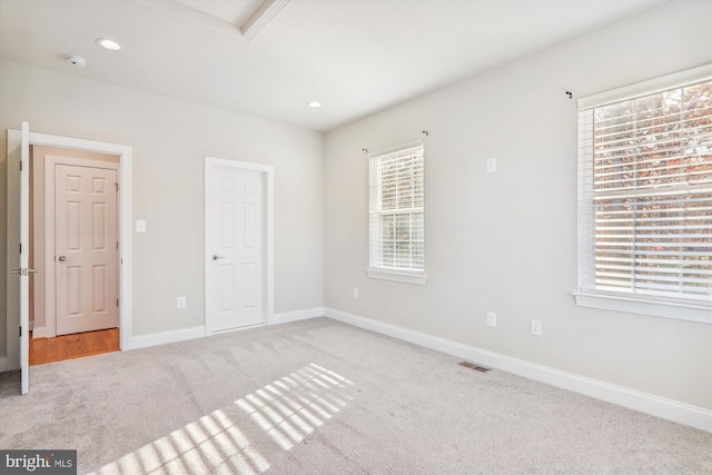 unfurnished bedroom featuring carpet floors and multiple windows