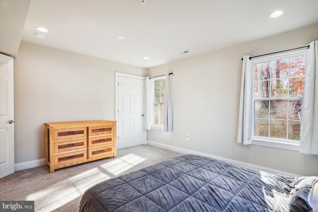 bedroom featuring dark carpet and multiple windows