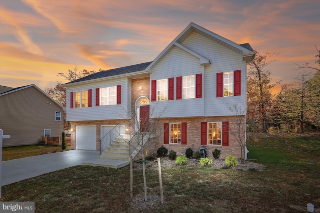 split foyer home featuring a yard and a garage