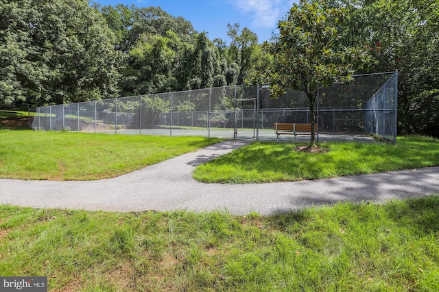 view of sport court with a yard