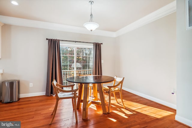 dining room with hardwood / wood-style flooring and ornamental molding