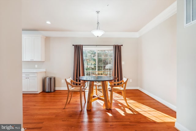 dining space featuring light hardwood / wood-style flooring and ornamental molding