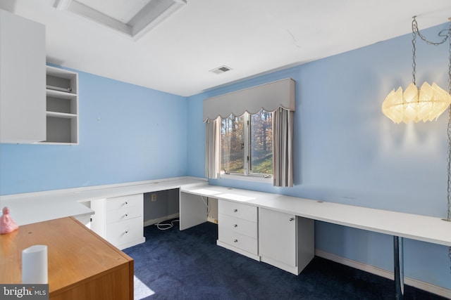 unfurnished office with dark colored carpet and built in desk