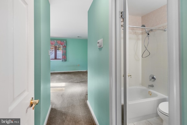 bathroom featuring tiled shower / bath combo and toilet