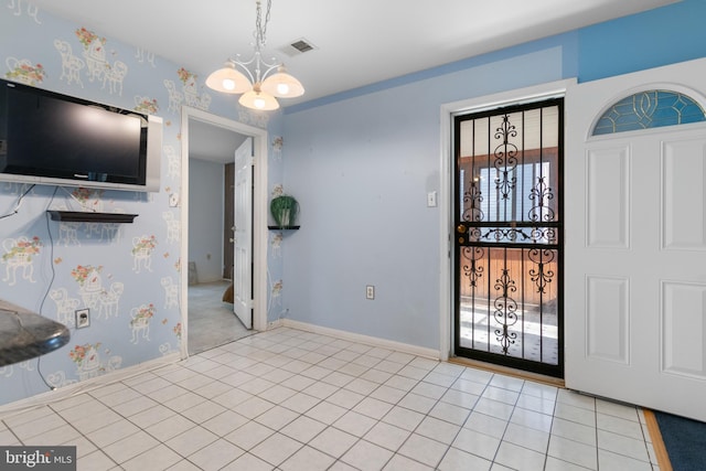 tiled entrance foyer with a notable chandelier