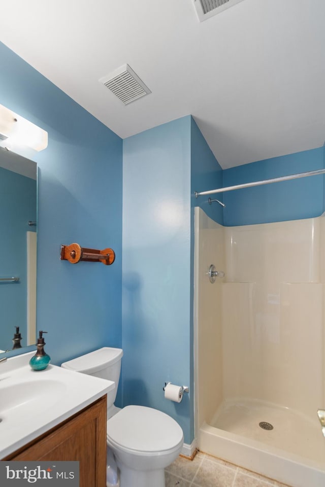 bathroom featuring tile patterned floors, vanity, toilet, and walk in shower