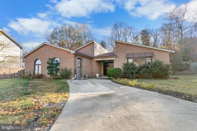 mid-century home featuring driveway and brick siding