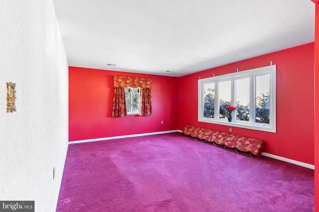 carpeted spare room featuring baseboards