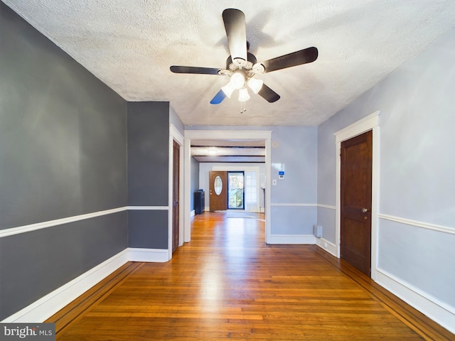 hall featuring hardwood / wood-style floors and a textured ceiling