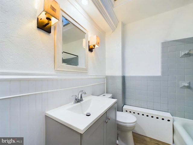 bathroom with a bathing tub, hardwood / wood-style floors, vanity, and toilet