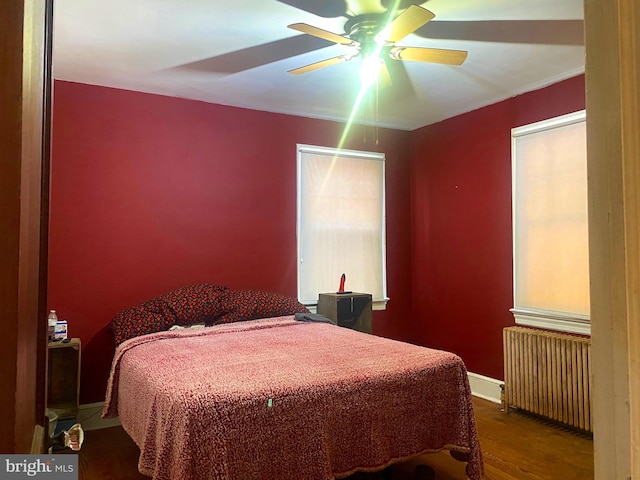 bedroom with radiator heating unit, hardwood / wood-style flooring, and ceiling fan