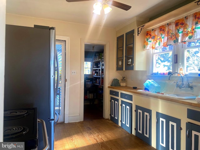 kitchen with range, stainless steel refrigerator, sink, hardwood / wood-style flooring, and ceiling fan