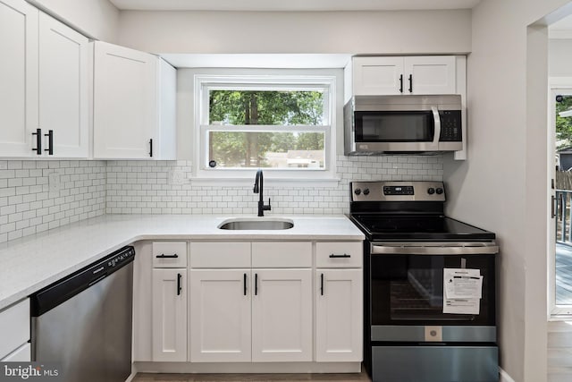 kitchen featuring white cabinets, sink, appliances with stainless steel finishes, and tasteful backsplash