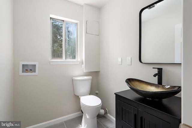 bathroom with toilet, vanity, and tile patterned flooring