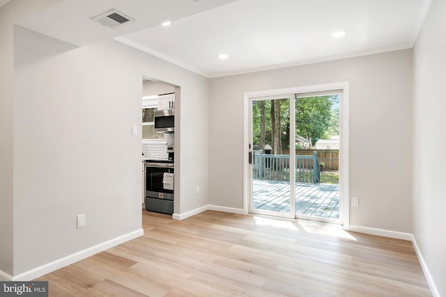 spare room featuring light hardwood / wood-style flooring and ornamental molding