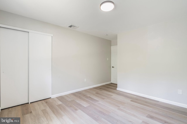 unfurnished bedroom featuring a closet and light hardwood / wood-style floors