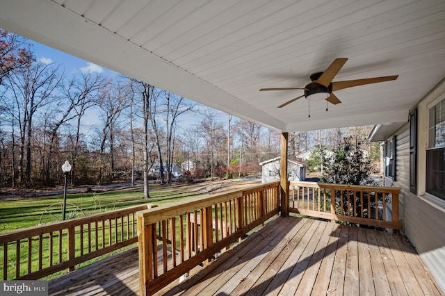 wooden terrace featuring a lawn and ceiling fan