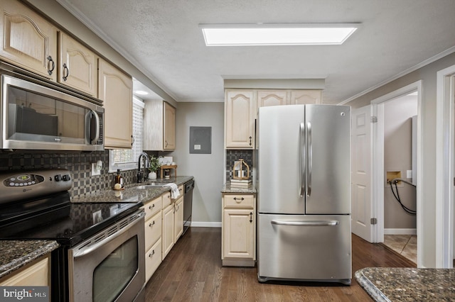 kitchen featuring dark wood-type flooring, stainless steel appliances, and dark stone counters