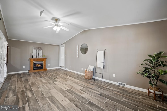 unfurnished living room featuring hardwood / wood-style floors, vaulted ceiling, ceiling fan, and ornamental molding