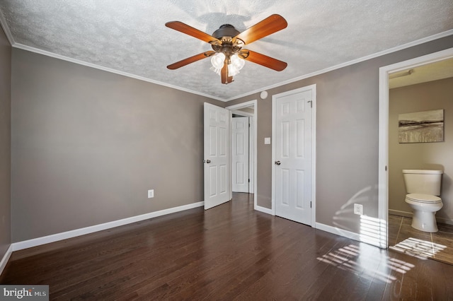 unfurnished bedroom featuring a textured ceiling, dark hardwood / wood-style floors, ceiling fan, and ensuite bathroom