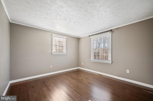 unfurnished room with a textured ceiling, crown molding, and dark wood-type flooring