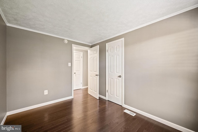 interior space with a textured ceiling, dark hardwood / wood-style flooring, and ornamental molding