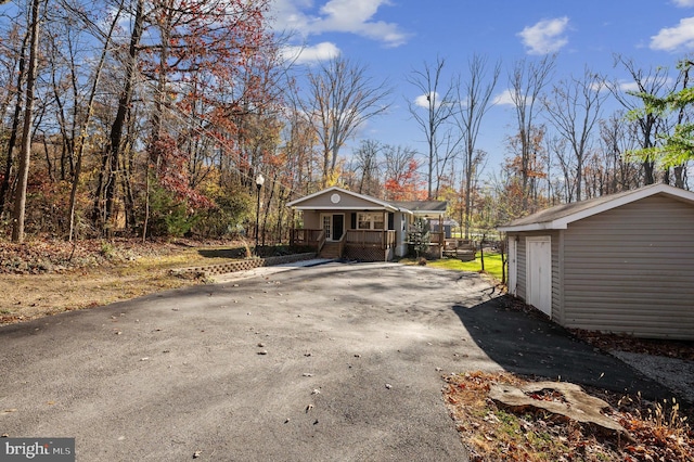 view of side of home featuring an outdoor structure, a porch, and a garage