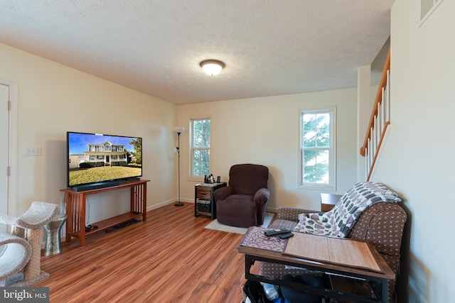 living room with wood-type flooring and a textured ceiling