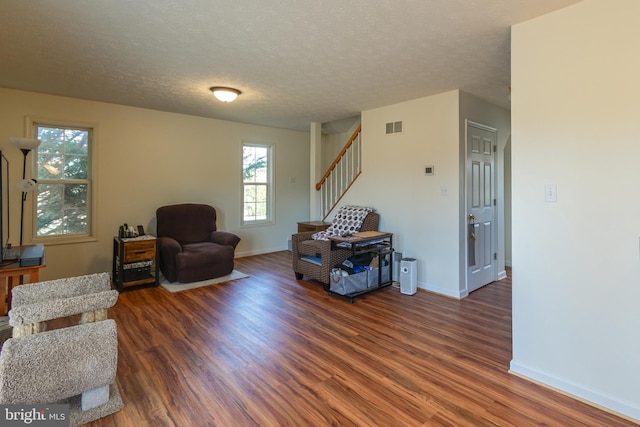 living area with a textured ceiling and dark hardwood / wood-style floors