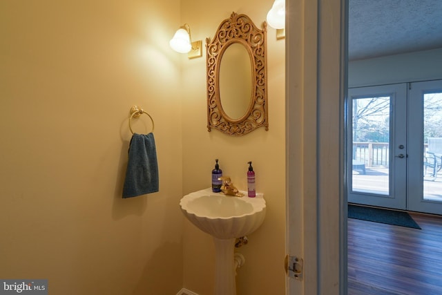 bathroom featuring french doors, wood-type flooring, and a textured ceiling