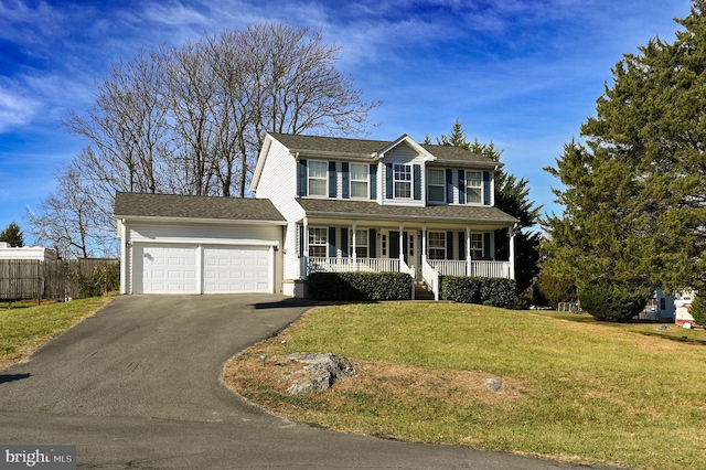 colonial home with a porch, a garage, and a front yard